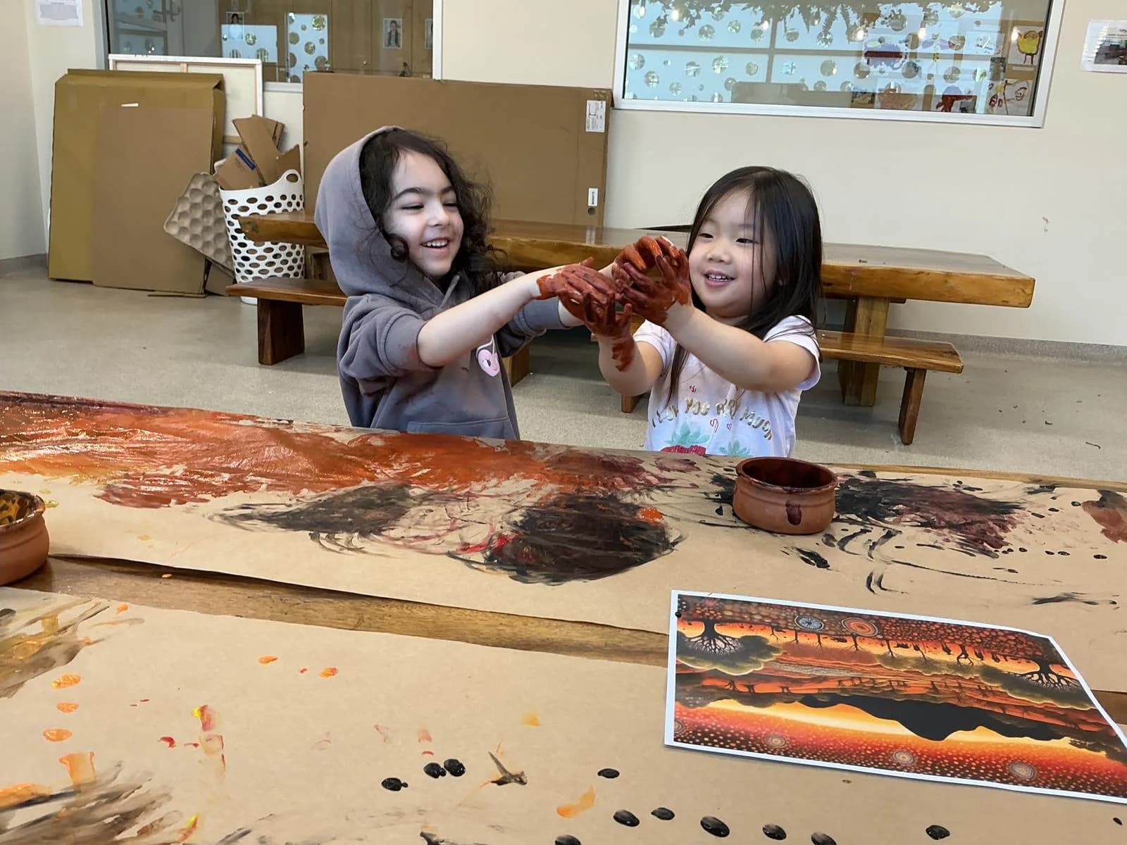 Two children with clay-covered hands at a Simba Education Sydney early learning centre