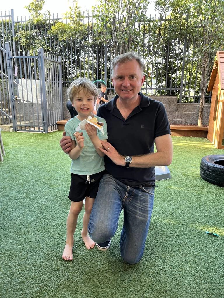 Dad and son in the outdoor play area at Simba Education Macquarie Park childcare centre