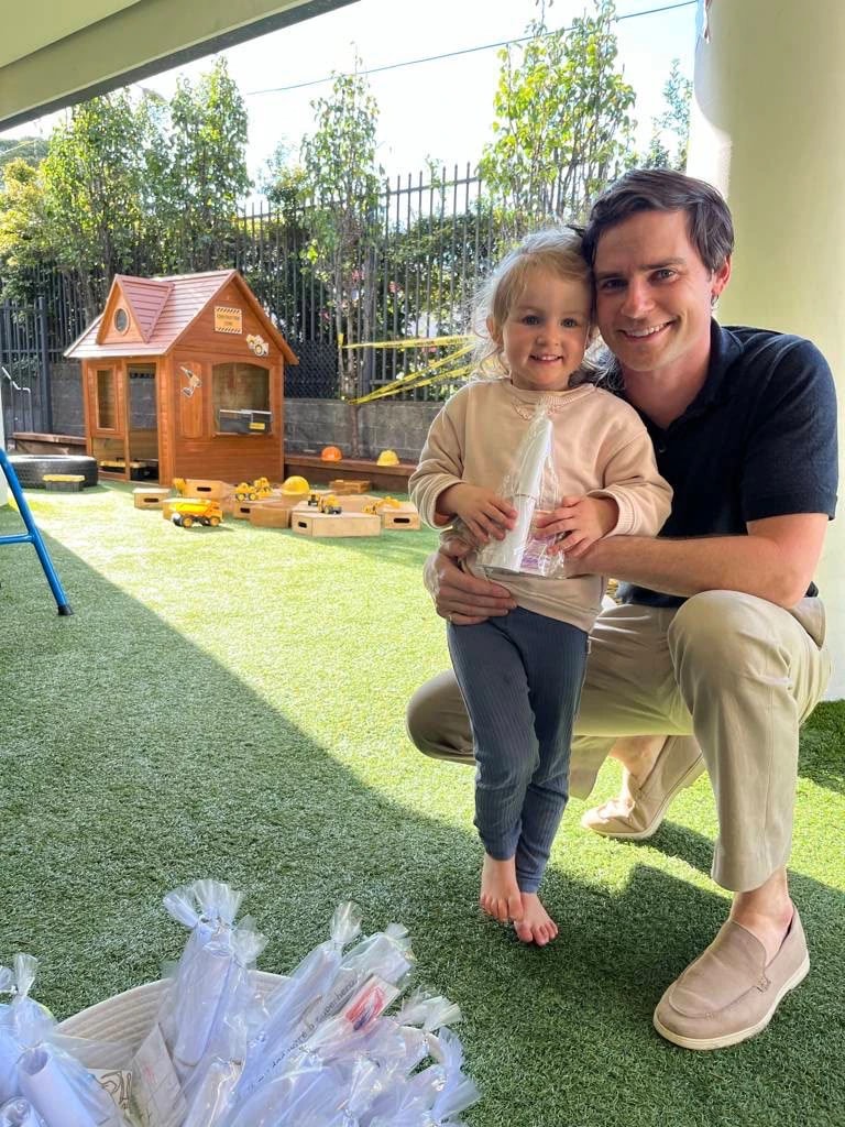 Dad and toddler beside the cubby house at Simba Education Macquarie Park childcare centre