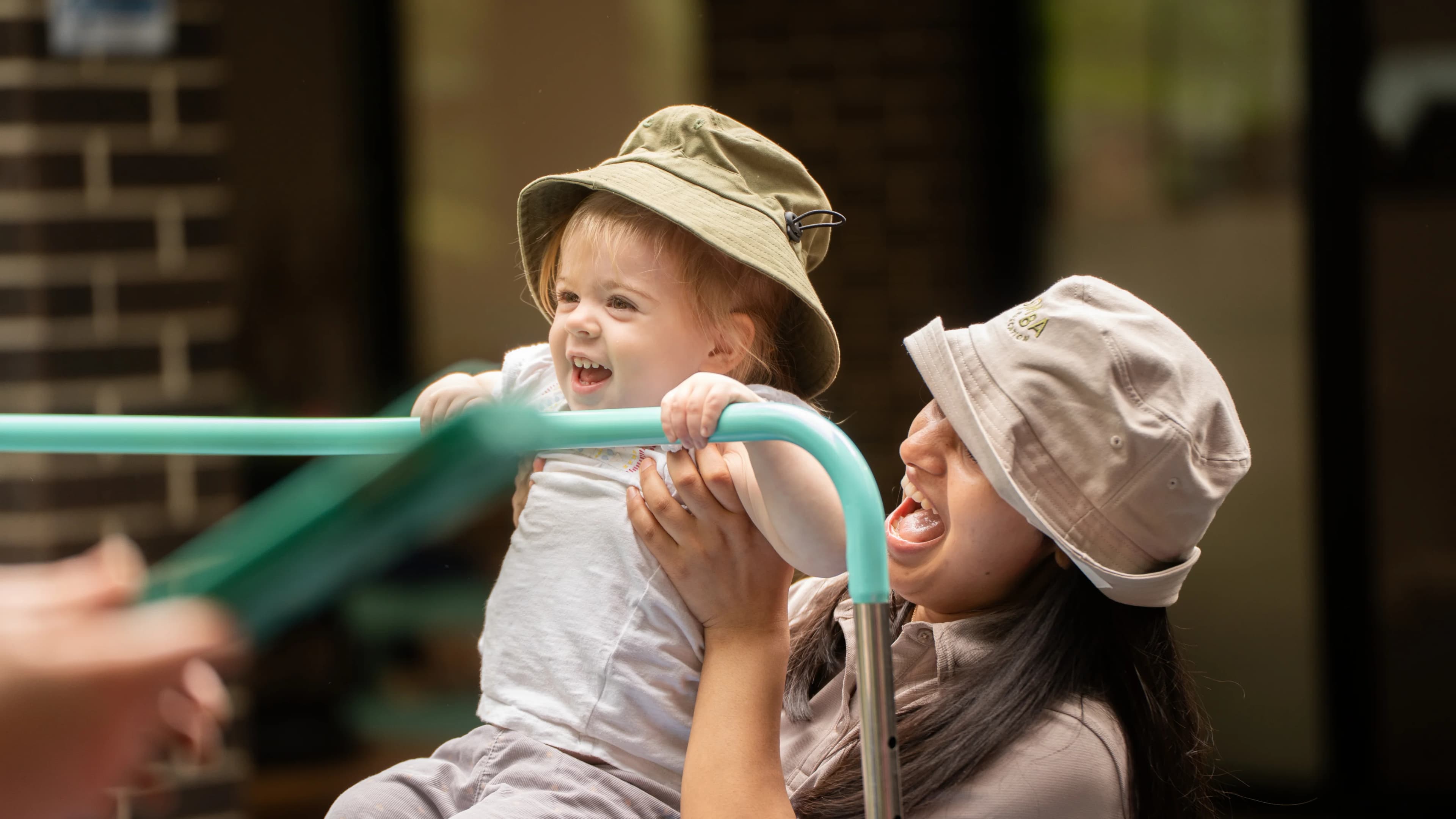 Educator with children on playground equipment